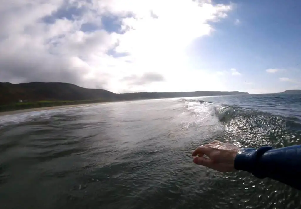 surfer's hand while riding a wave captured with a gopro mouth mount