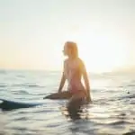 lady surfer sitting on board