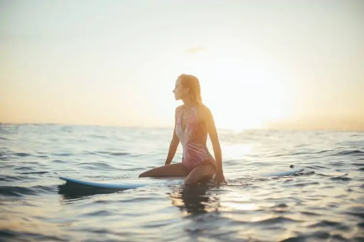 lady surfer sitting on board